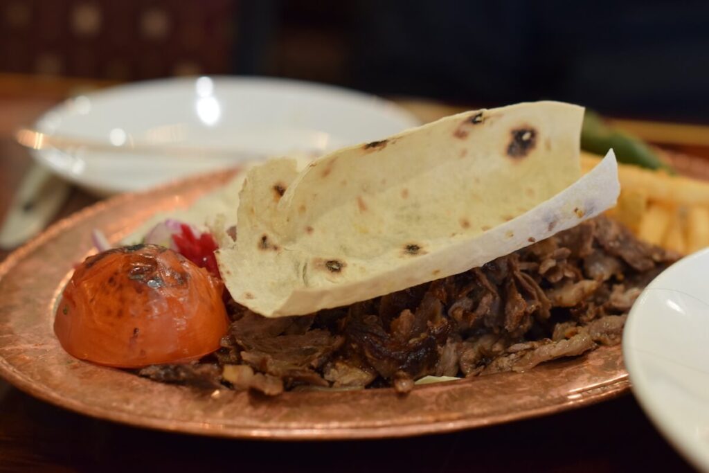 Beef doner plate with wood-fired bread and grilled tomato at Iskender's in Niagara Falls