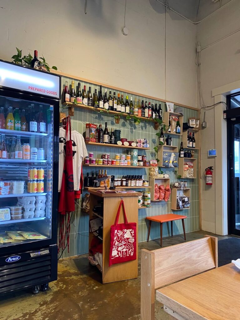 Condiments, wine, and snacks on wall shelves at the entrance of Fat Rabbit in St. Catharines